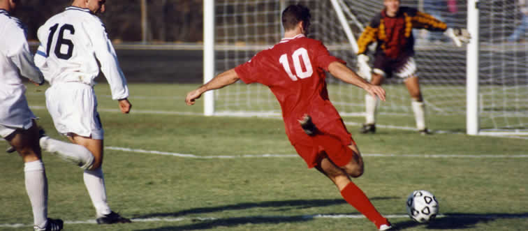 Check out those high-energy kicks and that classic checkered ball! Which world-famous sport is unfolding on this field?