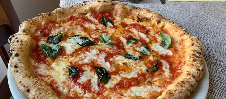Picture a cheese pull so epic it looks like a classic Saturday-morning gag. Where did this legendary Pizza slice originate?